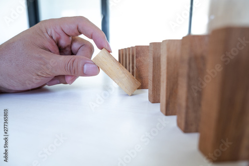 Image of hand holding blocks wood game to growing up of business. Risk of management and strategy plan