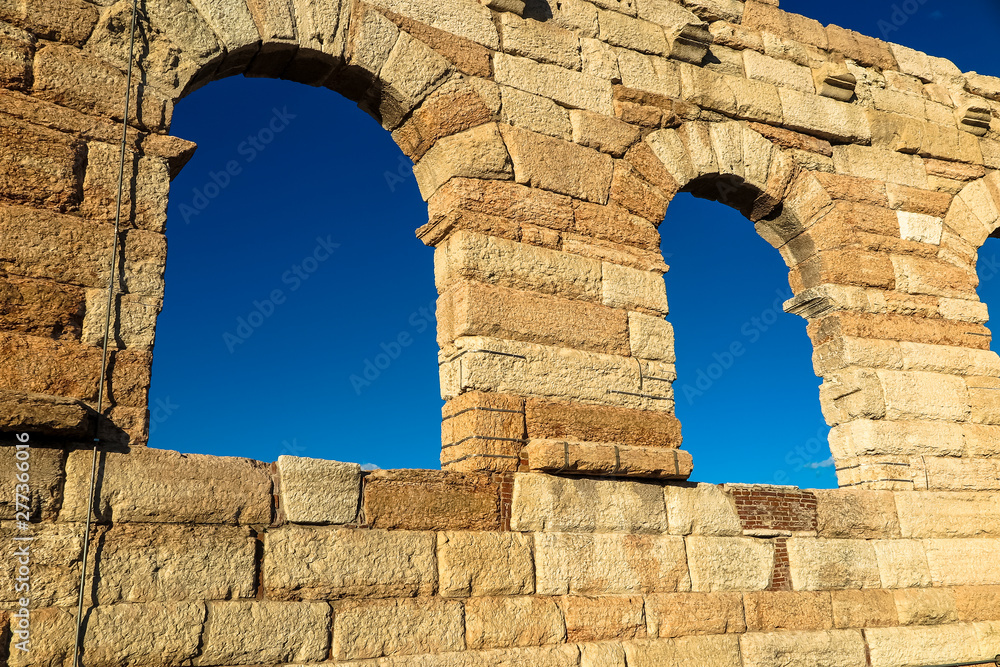 Old stone wall with arched windows of Verona Arena, Italy