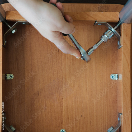 Hands screwing a screw with...