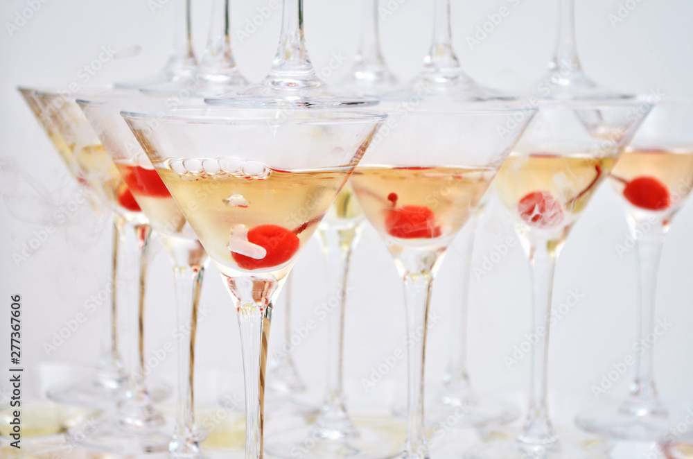 Triangular martini glasses, filled with champagne with cherries and liquid nitrogen, in the shape of a pyramid Triangular martini glasses, filled with champagne with cherries and liquid nitrogen, in the shape of a pyramid