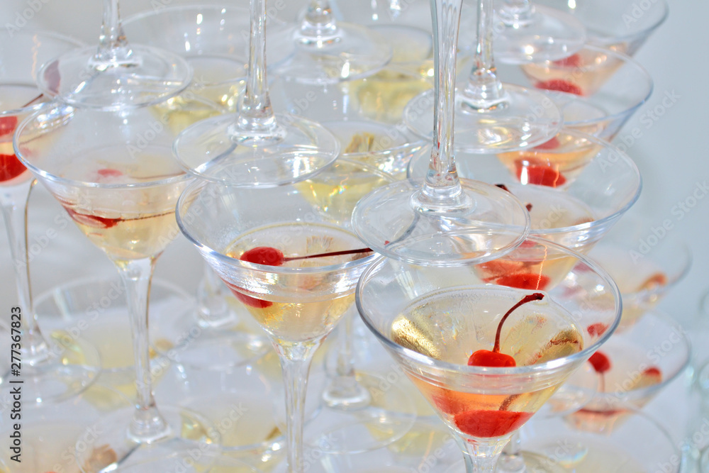 Triangular martini glasses, filled with champagne with cherries and liquid nitrogen, creating steam, top view Triangular martini glasses, filled with champagne with cherries and liquid nitrogen, creating steam, top view