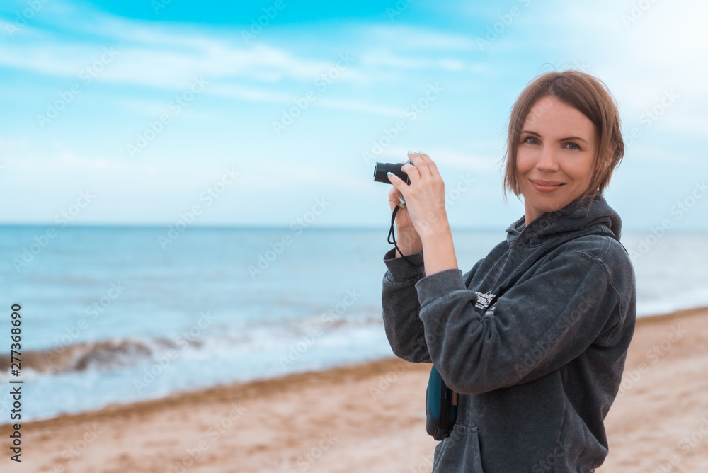 The woman of average years makes a photo on the seashore, ocean. The woman of average years makes a photo on the seashore, ocean.