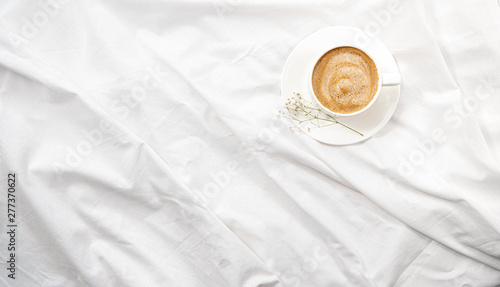 Morning flatlay in white bed. Coffee and morning routine. Copy space. Concept minimalism photo