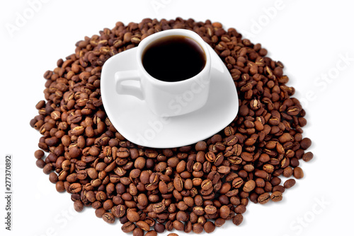 white cup of coffee on a white saucer stands on a hill of coffee beans on a white background isolate