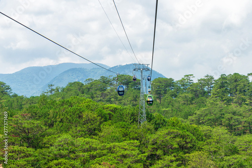 Funicular moves over tropical forest in mountains in Vietnam