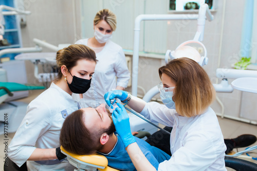 Dental clinic. Professional doctor dentist treats teeth to the patient in the office on modern equipment. Dental insurance.