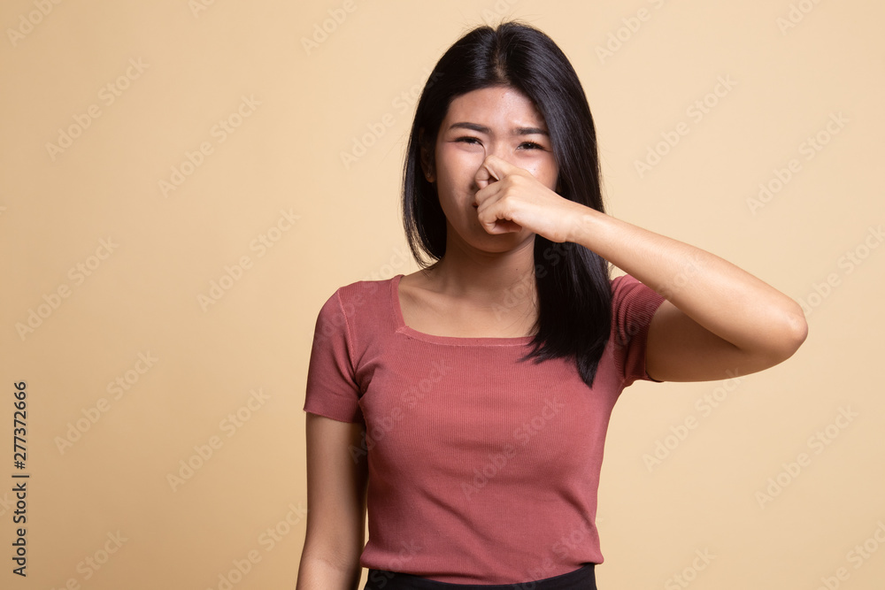 Young Asian woman holding her nose because of a bad smell. Young Asian woman holding her nose because of a bad smell.