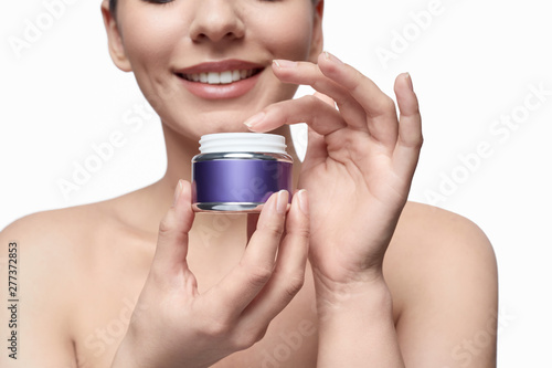 Smiling model using skin cream photo