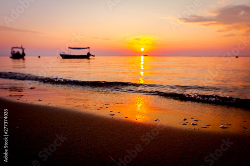 Silhouetted shot of beautiful sunrise with fisherman boats on the water © Roman_23203