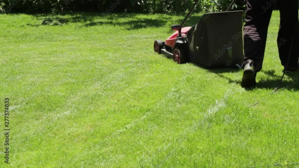 Kyrgyzstan, may 2019, Man mowing the lawn at home electric lawn mower Kyrgyzstan, may 2019, Man mowing the lawn at home electric lawn mower