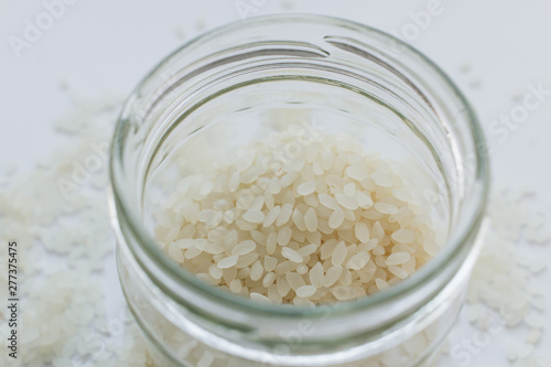 Pile of raw white rice in jar , macro 