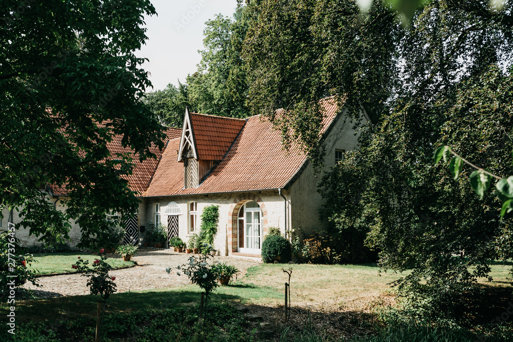 View of a traditional German rural house among the trees. View of a traditional German rural house among the trees.