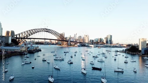 Camera rise up of daytime Harbour bridge, with Sidney skyline in the background photo