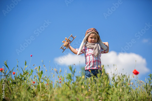 Beautiful toddler baby boy, child playing with airplane in poppy fiead, , sunny afternoon