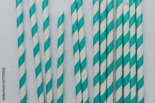 Pile of striped cocktail straws over white background
