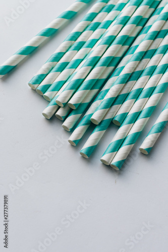 Pile of striped cocktail straws over white background
