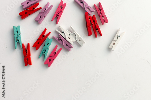 Pile of scattered clothes pegs isolated on white background