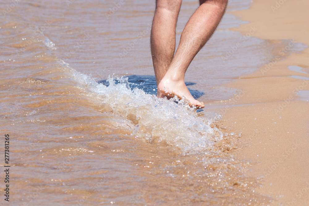 Close up on moving feet of a man walking on the beach. Close up on moving feet of a man walking on the beach.