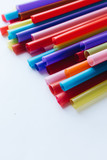 Pile of colorful cocktail straws over white background