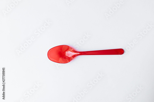 Red plastic spoons flat lay on white background