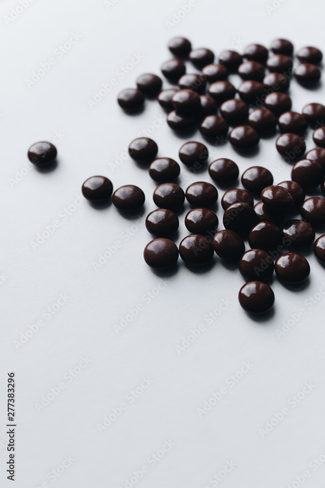 Pile of scattered chocolate dragee on white background Pile of scattered chocolate dragee on white background