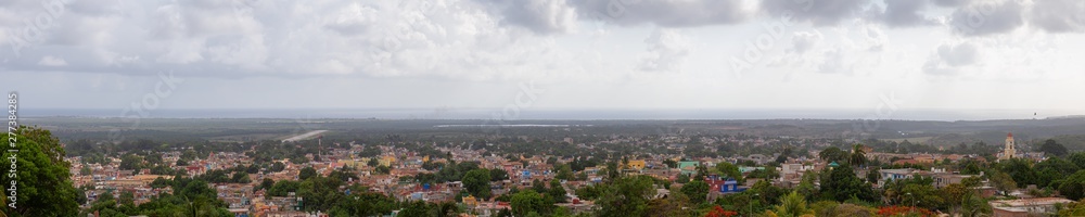 Aerial panoramic view of a small touristic Cuban Town during a colorful and cloudy sunset. Taken in Trinidad, Cuba.