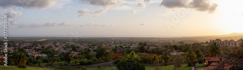 Aerial panoramic view of a small touristic Cuban Town during a colorful and cloudy sunset. Taken in Trinidad, Cuba.