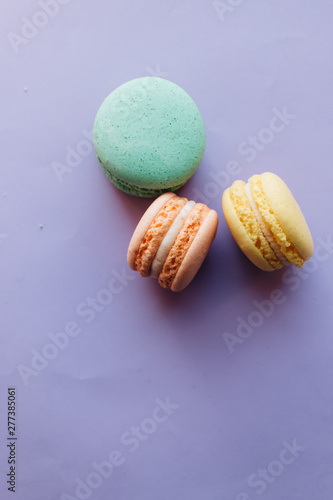 Composition of delicious macaroons on purple background