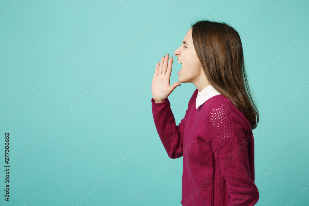 Young fun upset perplexed disturb brunette woman girl scream with hand at mouth posing isolated on blue wall background studio portrait. People sincere emotions lifestyle concept. Mock up copy space. Young fun upset perplexed disturb brunette woman girl scream with hand at mouth posing isolated on blue wall background studio portrait. People sincere emotions lifestyle concept. Mock up copy space.