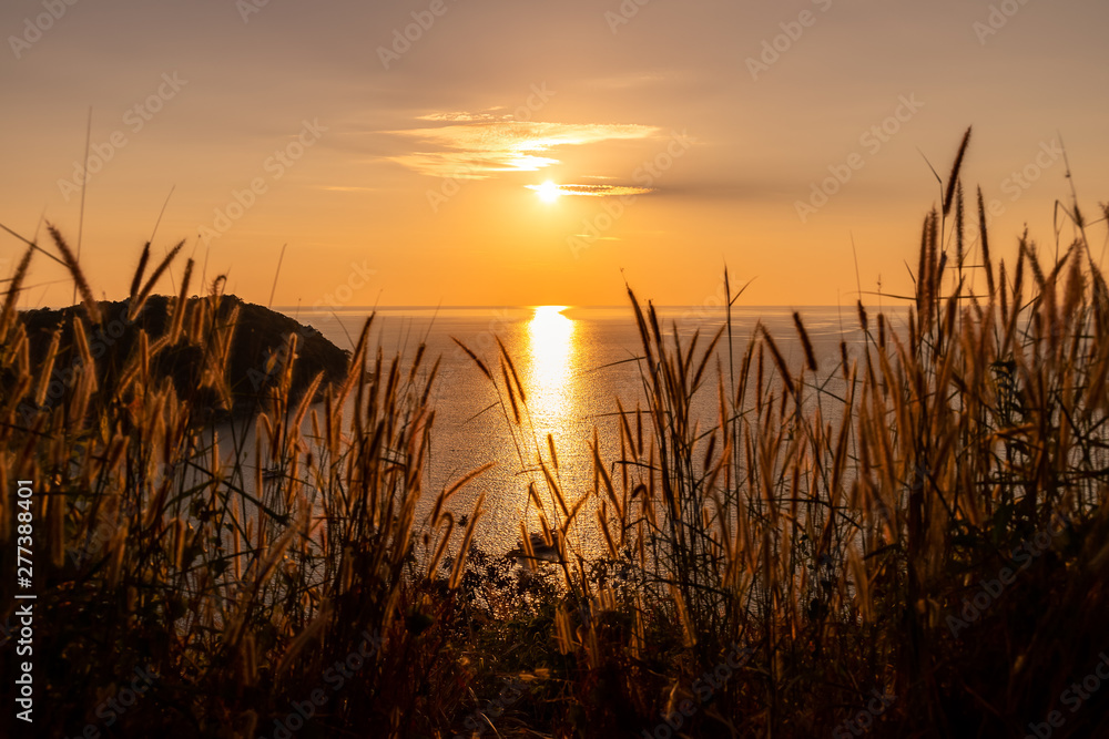 Obraz premium Beautiful sunset on Andaman sea at Windmill View Point near Laem Promthep Cape, Phuket, Thailand