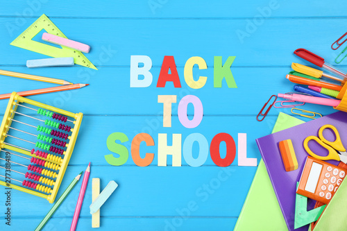Text Back To School with stationery on blue wooden table