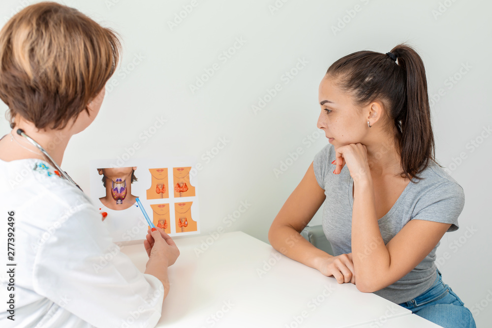 Therapist tells a young patient about the thyroid gland and shows pictures Therapist tells a young patient about the thyroid gland and shows pictures