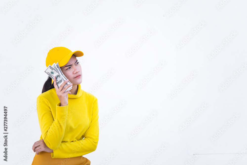 Portrait of beautiful asian woman in yellow cloths on dirty white wall,Hipsters girl wear yellow hat take a picture,Thailand people have a lot dollar money in hand Portrait of beautiful asian woman in yellow cloths on dirty white wall,Hipsters girl wear yellow hat take a picture,Thailand people have a lot dollar money in hand