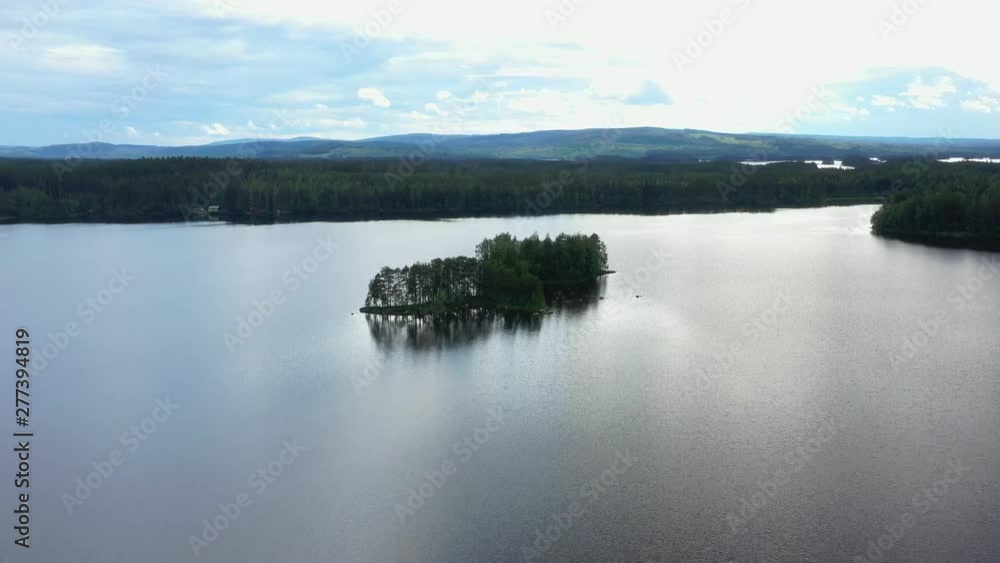 The Drone Orbits around a Small Island, on a Fishing Lake in Norra Flät, Sweden. 4K Video in Day Time. The Drone Orbits around a Small Island, on a Fishing Lake in Norra Flät, Sweden. 4K Video in Day Time.