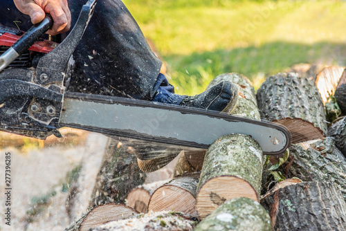 man cutting woods with chainsaw