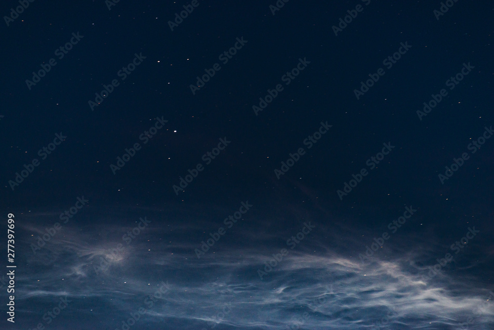Noctilucent clouds close up on a summer night. Glowing clouds in the night sky. Noctilucent clouds close up on a summer night. Glowing clouds in the night sky.