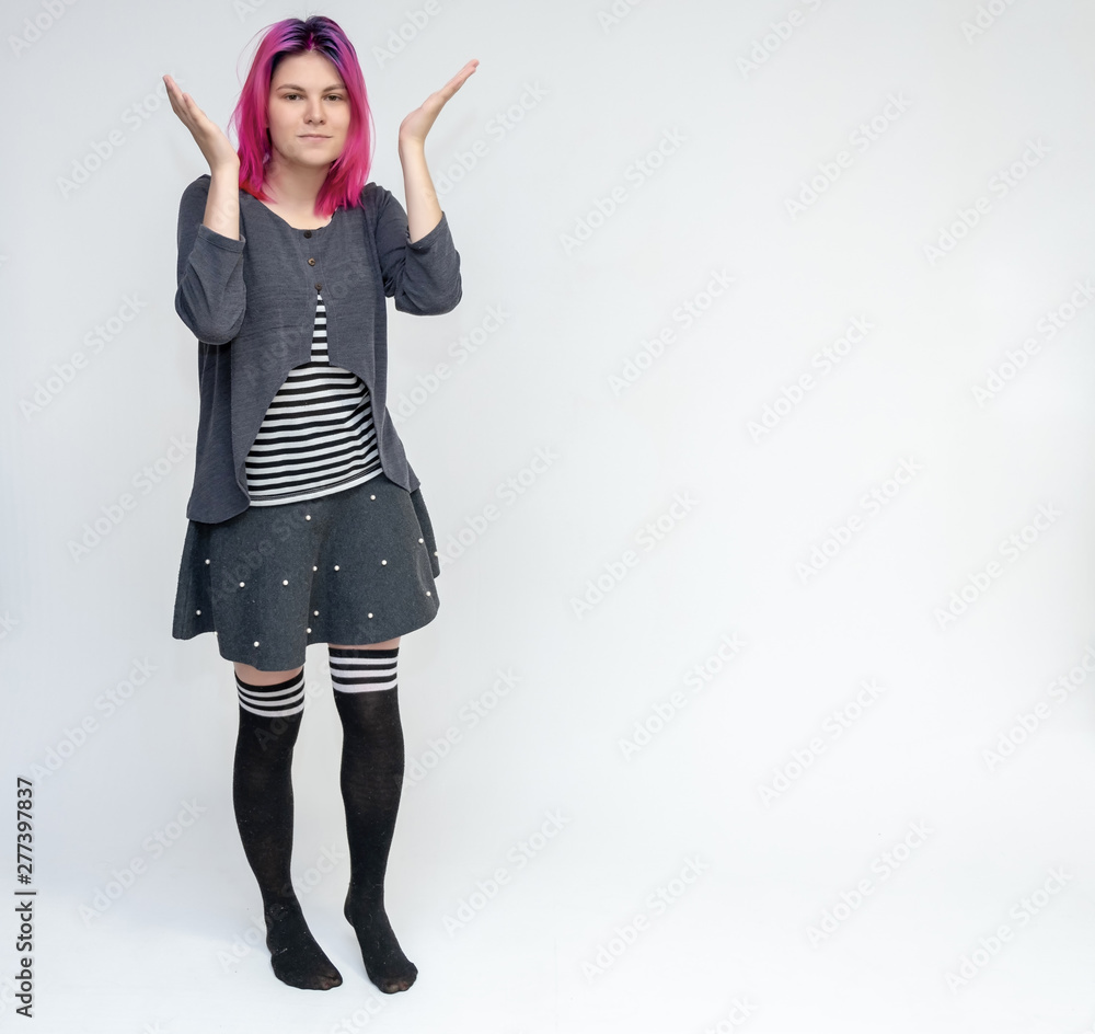 Full-length portrait of young pretty teenager girl in gray suit with beautiful purple hair on a white background in the studio. Talking, smiling, showing hands with emotions. Full-length portrait of young pretty teenager girl in gray suit with beautiful purple hair on a white background in the studio. Talking, smiling, showing hands with emotions.