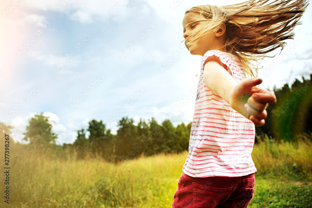Little girl running across the field at sunset. Concept of happy summer. Little girl running across the field at sunset. Concept of happy summer.