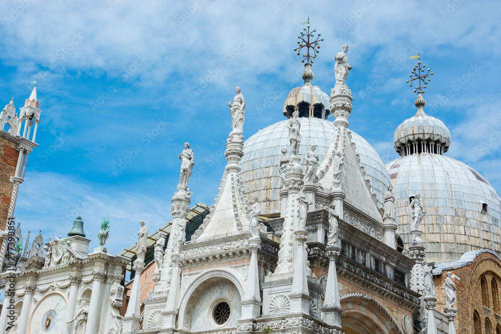 The architecture of the Doge's Palace from the courtyard: the clock, sculptures and domes, Venice, Italy.