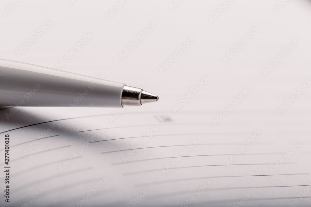 Opened notepad with automatic plastic ballpoint pen close up. Toned vintage Opened notepad with automatic plastic ballpoint pen close up. Toned vintage