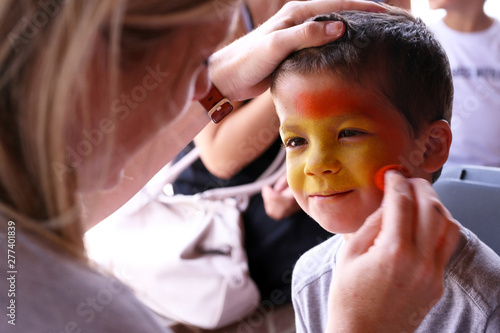 Artist painting a boys face with a sponge