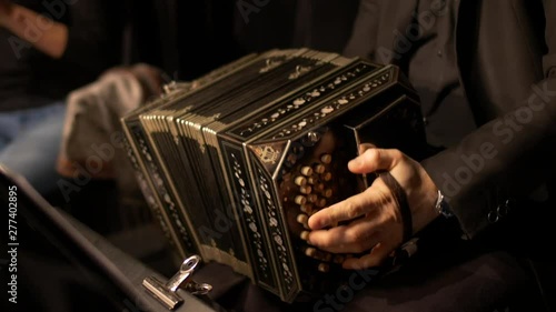 A Bandoneon accordion player is practicing for a tango music show.
