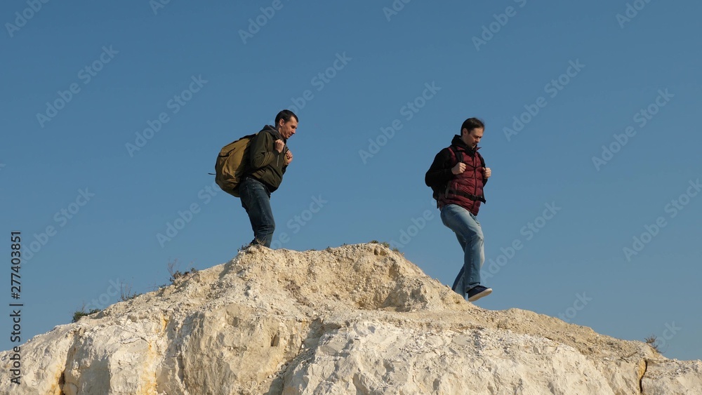 traveler overcomes a mountain pass. three climbers climb one after the other on white rock. teamwork of business people. Team traveler goes to victory and success.