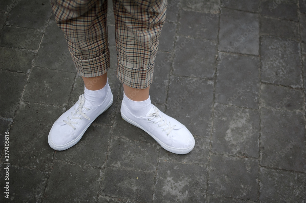 White sneaker shoes standing on the street. Hipster or casual concept White sneaker shoes standing on the street. Hipster or casual concept
