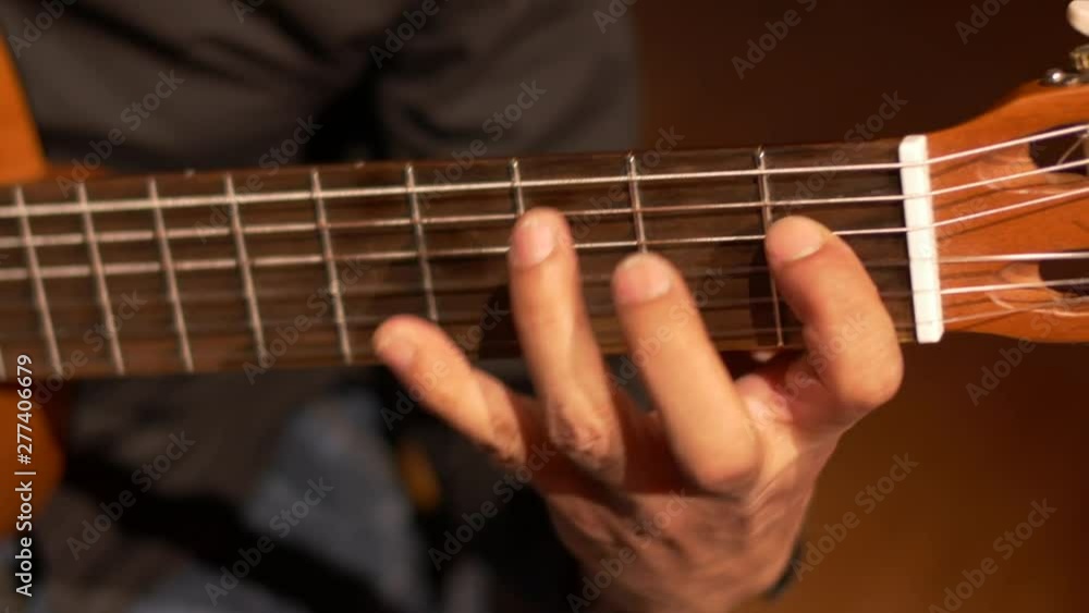 Close-up of a skilled guitar players hand holding the strings of a spanish guitar. Close-up of a skilled guitar players hand holding the strings of a spanish guitar.