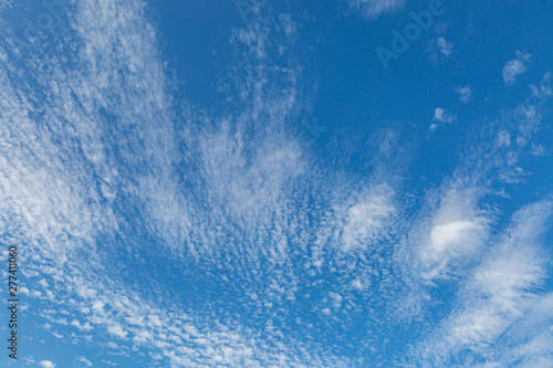 Looking up at a full frame photograph of blue sky and wispy white clouds