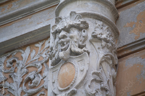 Old column with a bas-relief in the form of a demonic face. Kiev, Ukraine