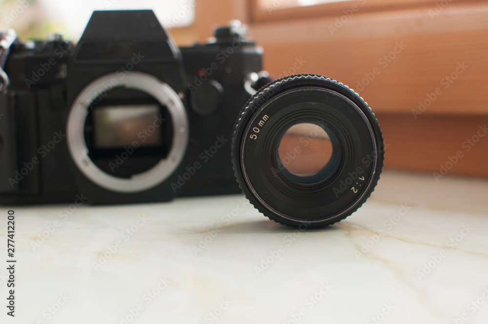 Old black film camera with lens
