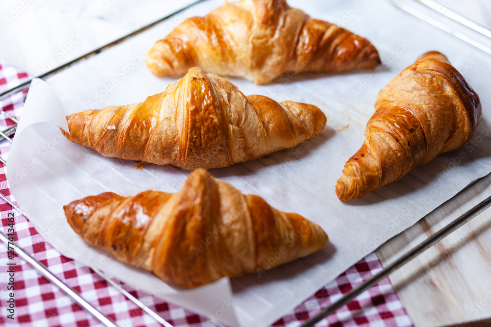 Tray with freshly baked french croissants. Served on a baking paper and red napkin. Perfect breakfast for sunday morning, sweet and delicious homemade pastry Tray with freshly baked french croissants. Served on a baking paper and red napkin. Perfect breakfast for sunday morning, sweet and delicious homemade pastry