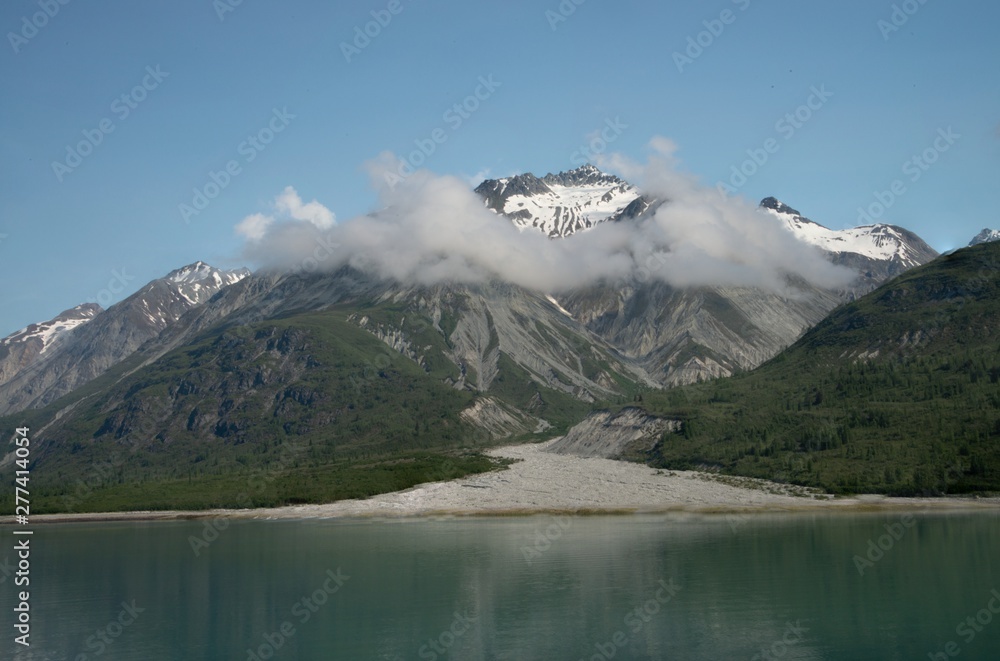 Looking between mountains to gravel trail with snow, clouds, and seagull. Looking between mountains to gravel trail with snow, clouds, and seagull.
